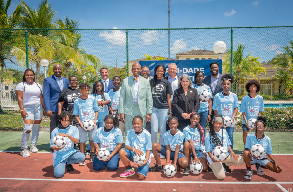 Kids and community leaders post for a photo at the home of a future mini-pitch in Miami
